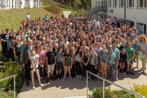 Gruppenfoto der ganzen Schule auf dem Hang vor dem Schulgebäude